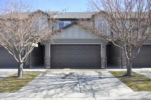 Traditional home featuring driveway, an attached garage, and brick siding