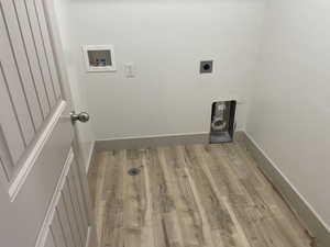 Laundry area featuring light wood-style floors, hookup for an electric dryer, and washer hookup