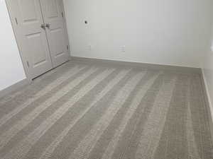 Unfurnished bedroom featuring light colored carpet and a closet