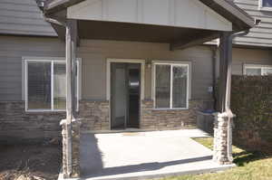 Entrance to property featuring covered porch and stone siding