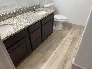 Full bath featuring light wood-style floors and double vanity