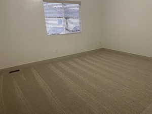 Empty room featuring carpet and baseboards