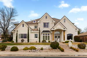 French country home with stone siding and stucco siding