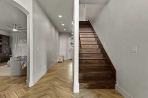 Stairway with parquet flooring, ceiling fan, and recessed lighting