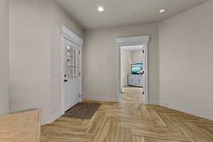 Foyer entrance featuring parquet flooring, recessed lighting, and healthy amount of natural light