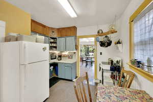 Kitchen with white appliances, open shelves, and light countertops