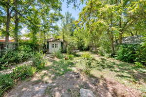 Fenced backyard featuring an outbuilding