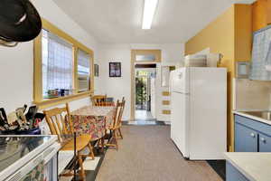Kitchen featuring white appliances, light countertops, blue cabinetry, and cooling unit