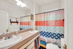 Full bath featuring double vanity and a shower with shower curtain