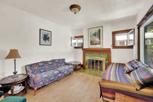 Living room with hardwood / wood-style floors and a tile fireplace