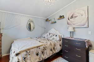 Bedroom featuring lofted ceiling, ornamental molding, and suspended lighting