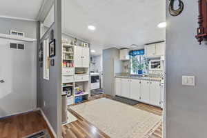 Kitchen featuring white cabinetry, open shelves, light countertops, light wood finished floors, and recessed lighting