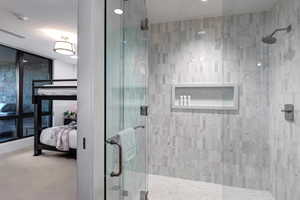 Full bath with tiled shower and carpet floors