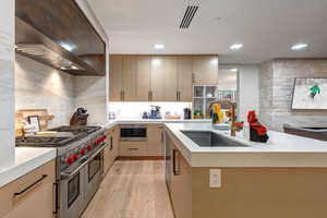 Kitchen featuring stainless steel appliances, light stone countertops, light wood-type flooring, modern cabinets, and light wood finish cabinets
