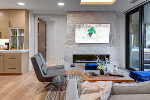 Living area featuring a high end fireplace and light wood finished floors