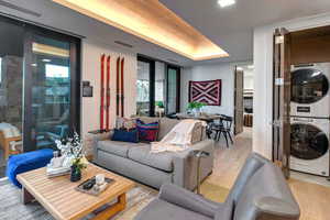 Living room featuring light wood finished floors and stacked washer / drying machine