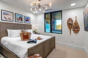 Bedroom featuring hanging lights and light colored carpet