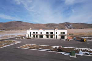 Aerial view of property and surrounding area featuring a mountainous background
