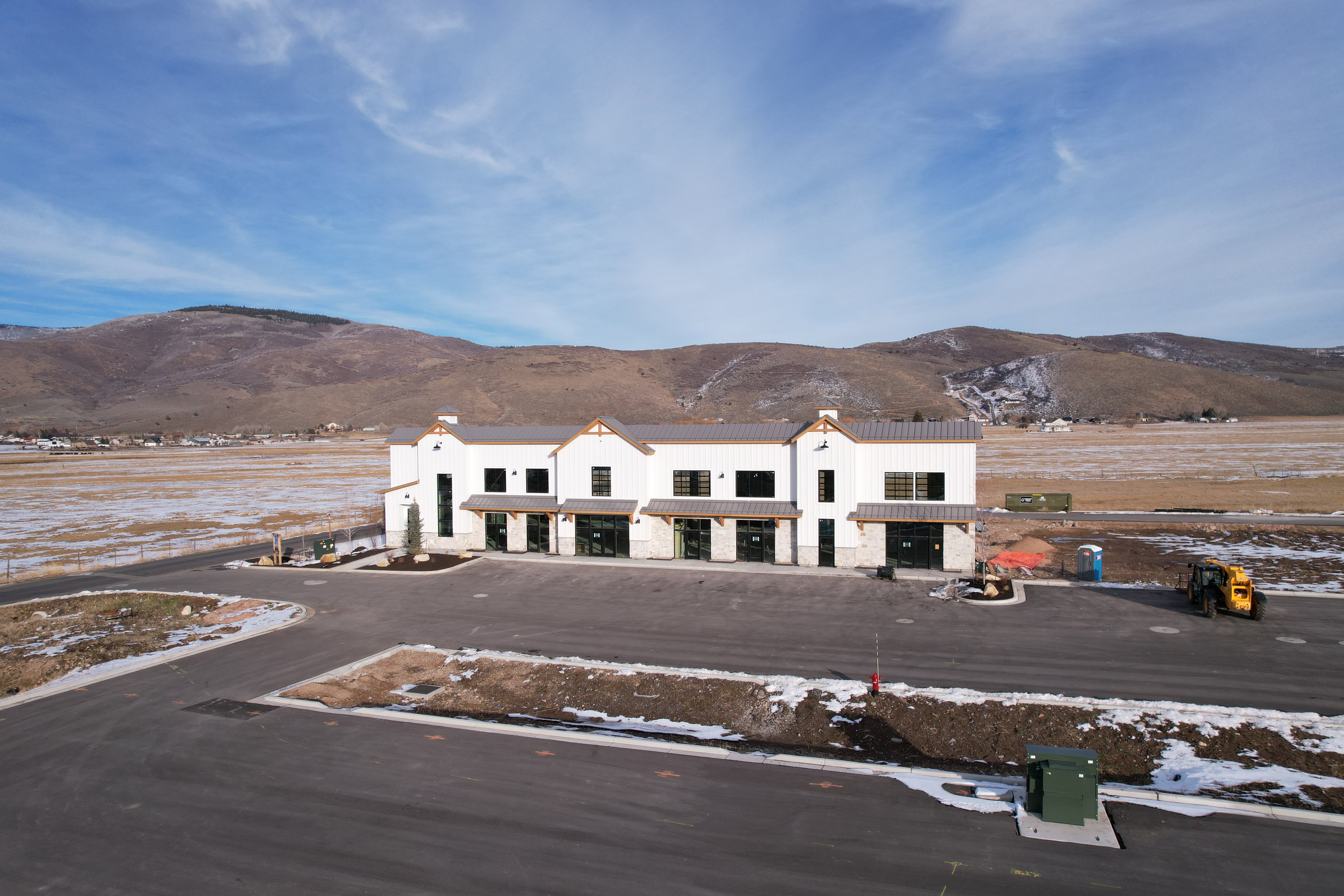 Aerial view of property and surrounding area featuring a mountainous background