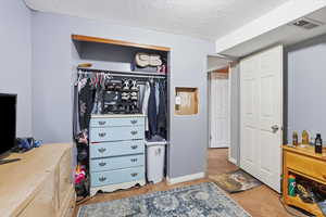 Bedroom featuring a textured ceiling and a closet