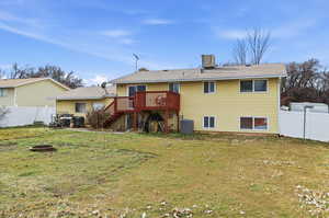 Rear view of house with a fire pit, a wooden deck, and a patio area