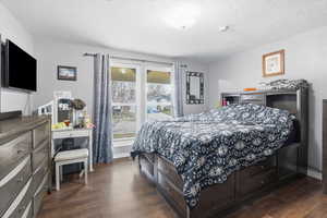 Bedroom featuring dark wood-style floors and a textured ceiling