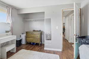 Bedroom with dark wood-type flooring and baseboards