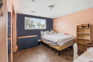 Bedroom featuring concrete floors and a textured ceiling