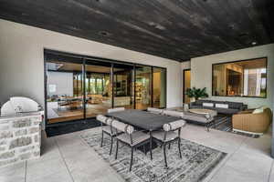 View of patio / terrace featuring an outdoor kitchen and an outdoor living / dining area