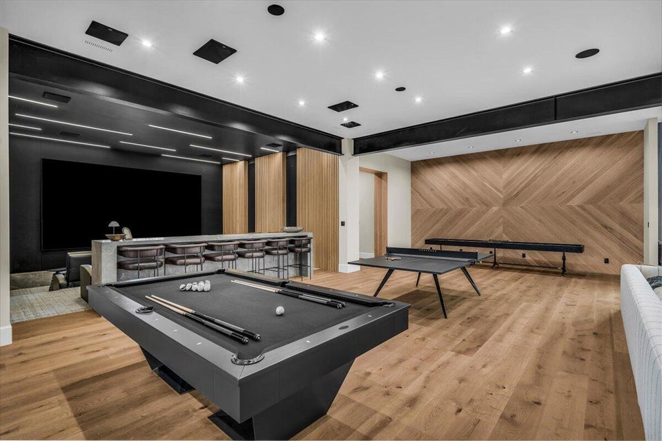 Playroom featuring beamed ceiling and wooden walls