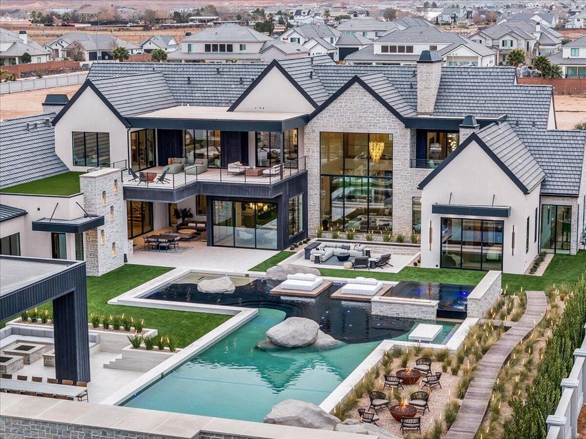 Rear view of house with an outdoor pool, a jacuzzi, a patio, and a residential view