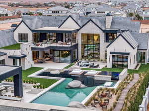 Rear view of house with an outdoor pool, a jacuzzi, a patio, and a residential view