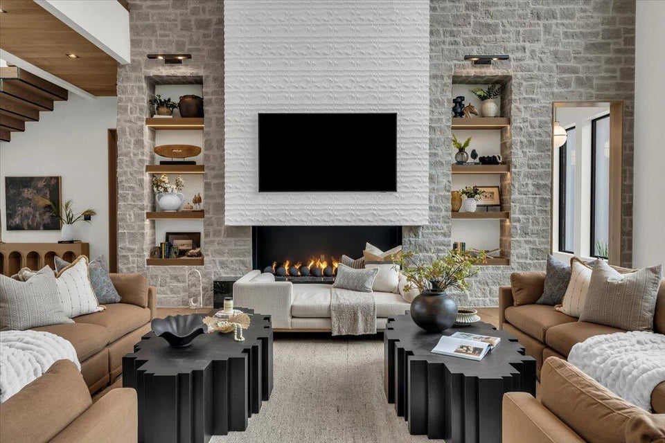 Living area featuring built in features and a stone fireplace
