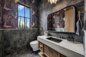 Bathroom with vanity and tile walls
