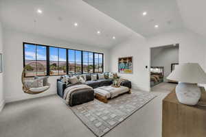Living area featuring light colored carpet, vaulted ceiling, and recessed lighting
