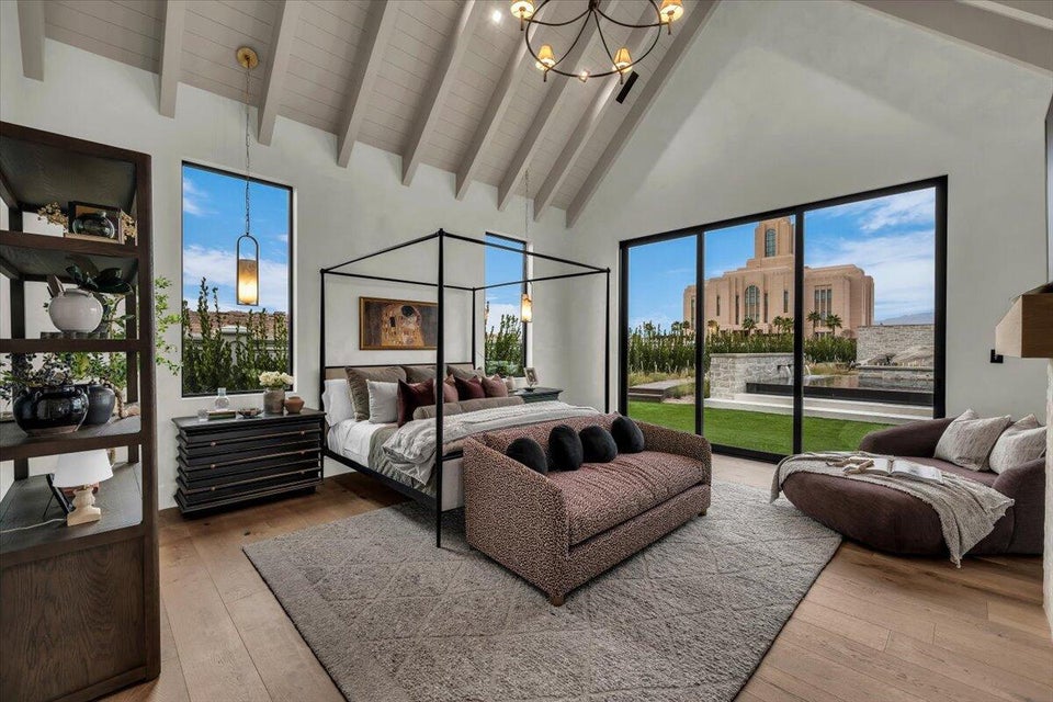 Bedroom with vaulted ceiling, light wood-style floors, hanging lights, and access to exterior