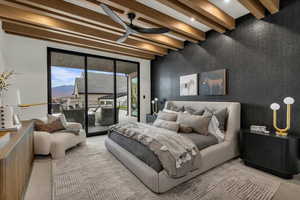 Carpeted bedroom with beam ceiling, an accent wall, access to outside, and a ceiling fan