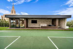 Back of property with stone siding and a wooden deck