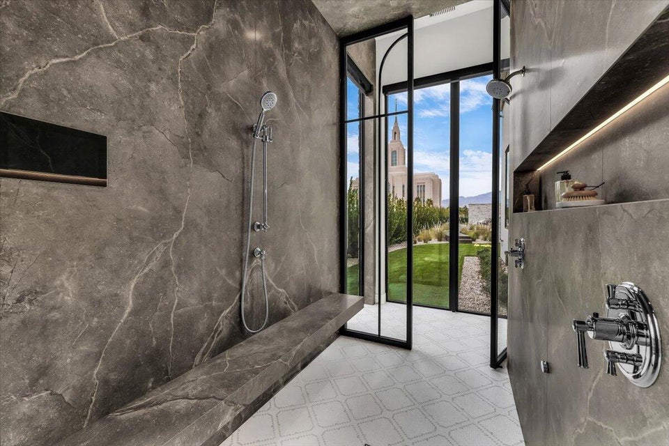 Bathroom featuring floor to ceiling windows and a marble finish shower