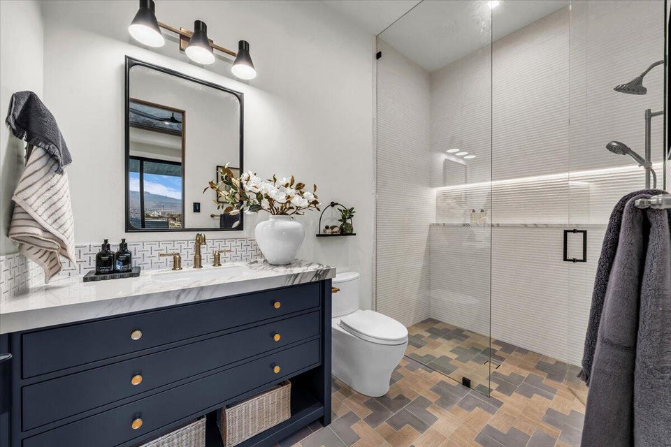 Full bathroom featuring a stall shower, vanity, and decorative backsplash
