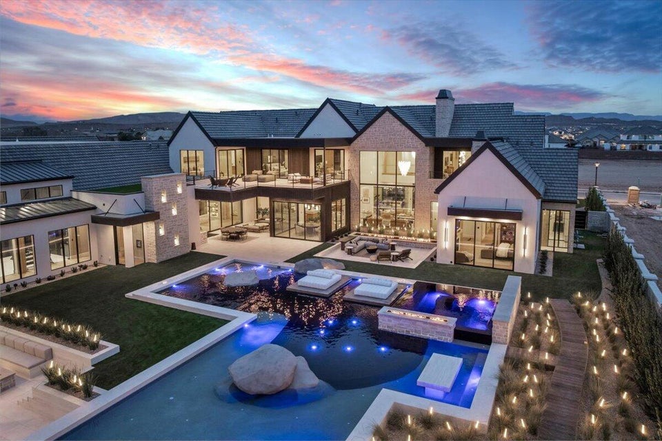 Rear view of property featuring an in-ground hot tub, an outdoor pool, a patio, and a chimney