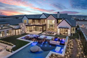 Rear view of property featuring an in-ground hot tub, an outdoor pool, a patio, and a chimney