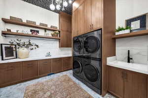 Laundry room featuring cabinet space and a chandelier