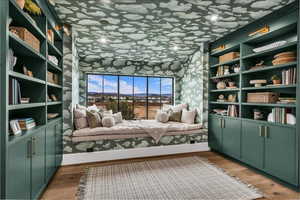 Sitting room featuring built in shelves and light wood-style flooring