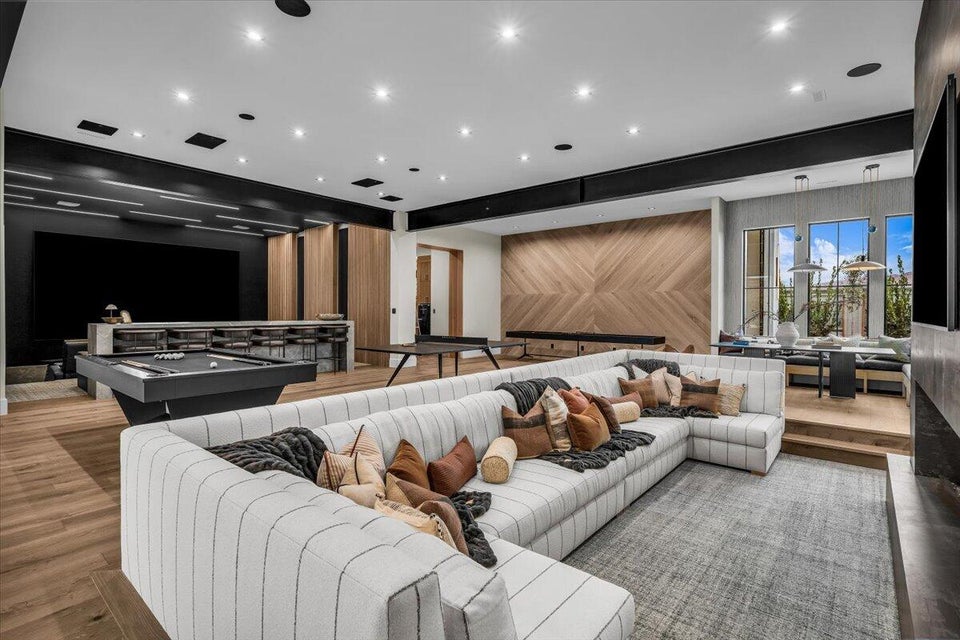 Sunken living room with wood finished floors, wood walls, recessed lighting, and an accent wall