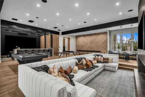 Sunken living room with wood finished floors, wood walls, recessed lighting, and an accent wall