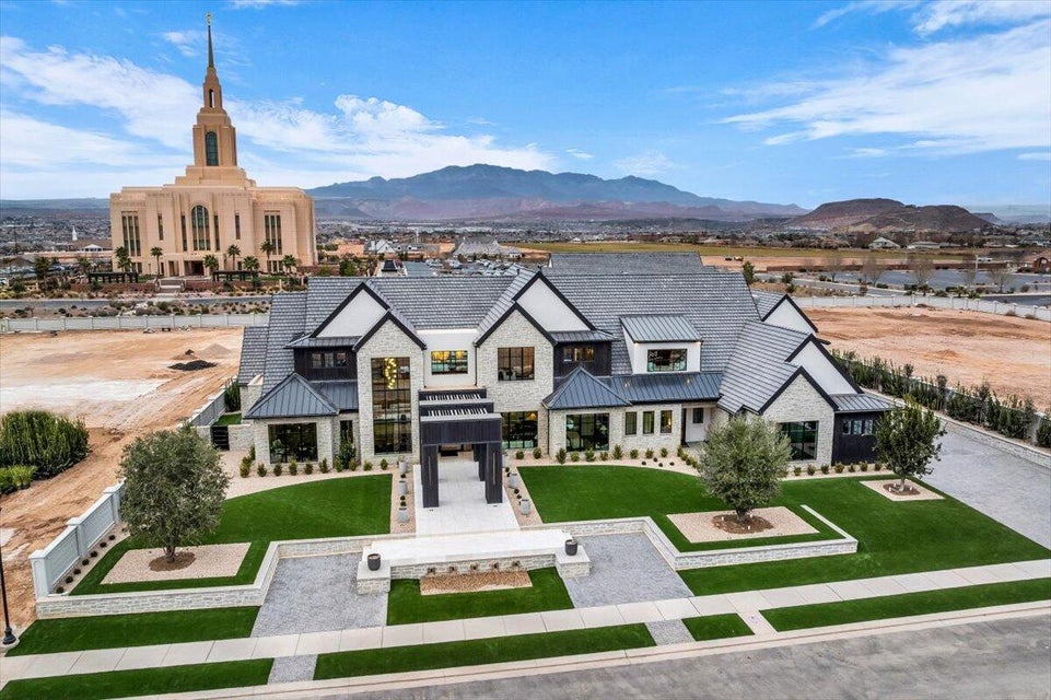 View of front facade with a standing seam roof, a mountain view, and a front lawn