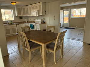 Dining area with light tile patterned floors; furniture included