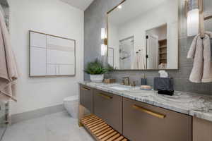 Bathroom with vanity, decorative backsplash, and a marble finish shower