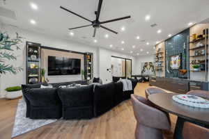 Living room with light wood-type flooring, a ceiling fan, and recessed lighting